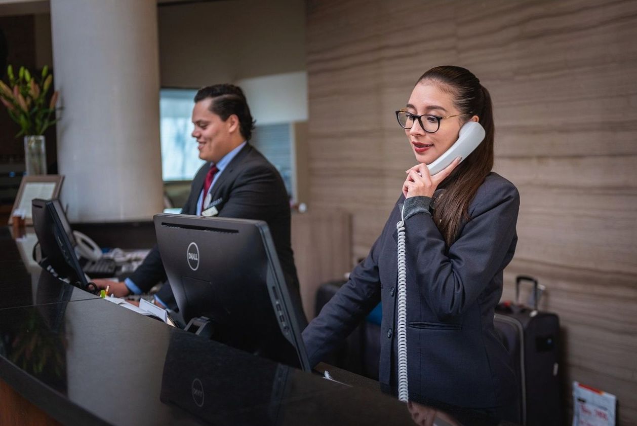 Front desk staff greeting guests at Plain Scope Agency